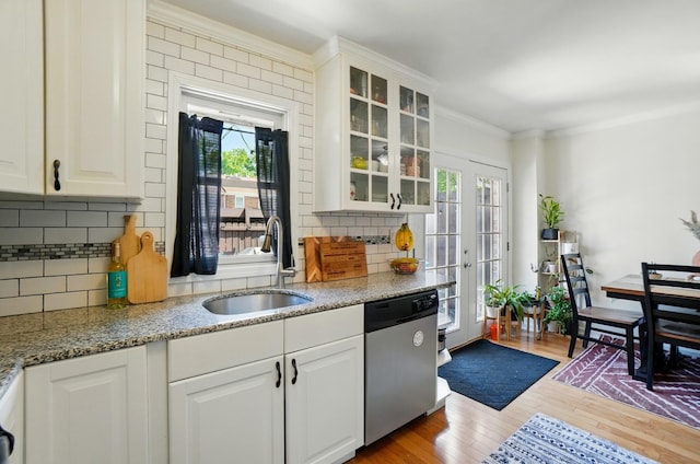 602 Dlyn St Unit H8, Columbus, OH 43228 - kitchen with stainless steel dishwasher, plenty of natural light, ornamental molding, glass insert cabinets, and wood finished floors