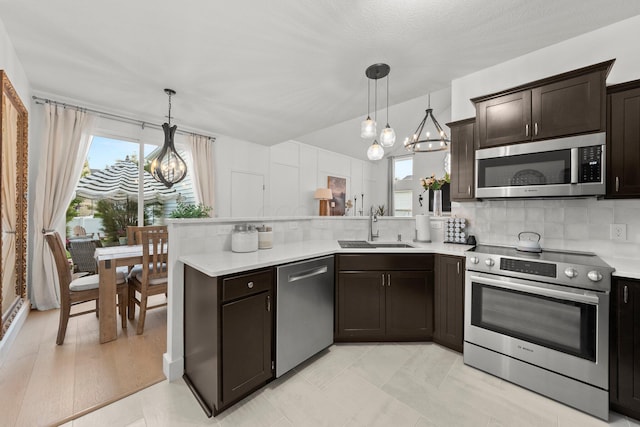 5431 Goose Falls Dr, Dublin, OH 43016 - kitchen featuring appliances with stainless steel finishes, a chandelier, a peninsula, decorative backsplash, and dark brown cabinetry