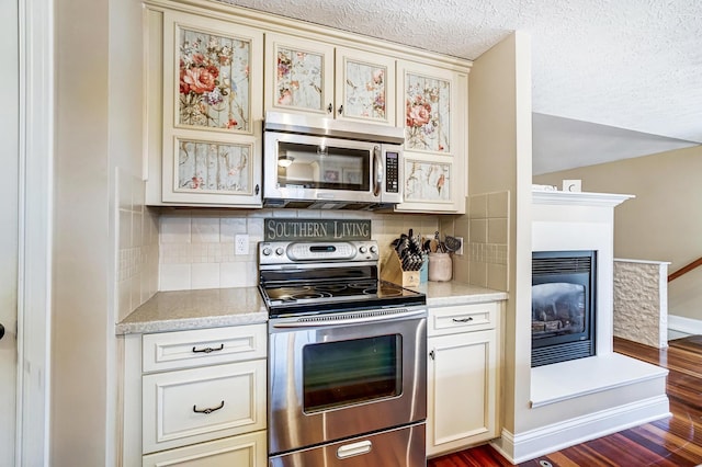 2474 Marthas Wood, Grove City, OH 43123 - kitchen with appliances with stainless steel finishes, dark wood-style flooring, cream cabinets, tasteful backsplash, and a textured ceiling
