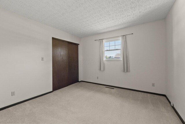 12475 Oak Dr, Orient, OH 43146 - unfurnished bedroom with light colored carpet, a closet, and a textured ceiling