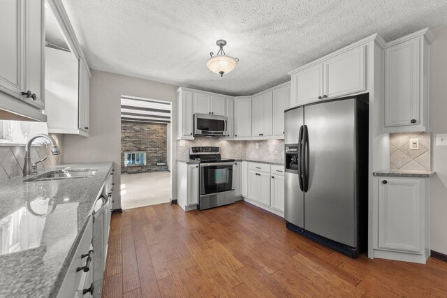 12475 Oak Dr, Orient, OH 43146 - kitchen featuring stainless steel appliances, dark wood finished floors, tasteful backsplash, and a textured ceiling