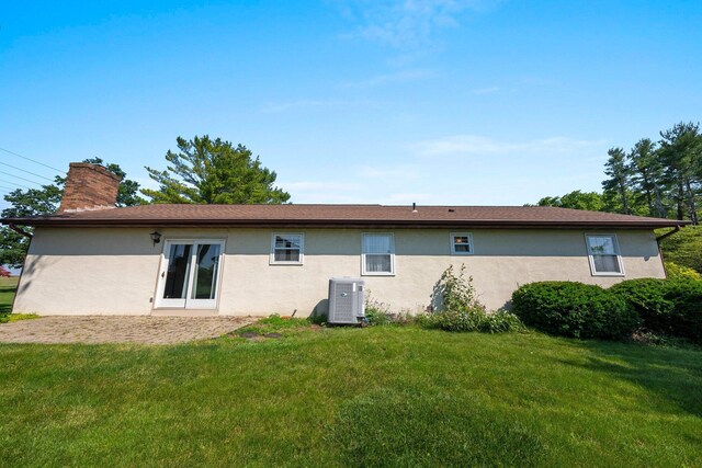 12475 Oak Dr, Orient, OH 43146 - rear view of house with stucco siding, a chimney, and a lawn