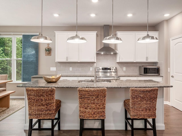 404 Colony Ridge Dr, Delaware, OH 43015 - kitchen featuring wall chimney exhaust hood, appliances with stainless steel finishes, backsplash, white cabinetry, and recessed lighting