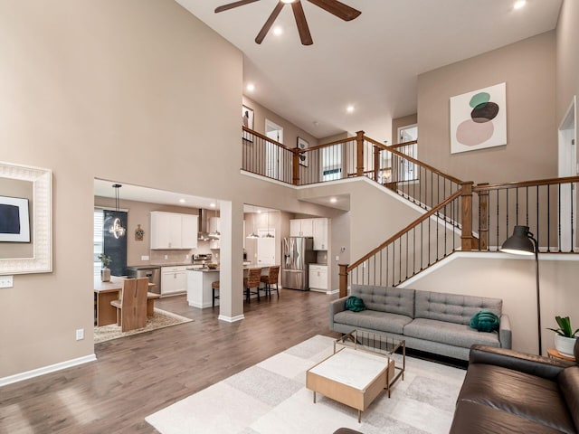 404 Colony Ridge Dr, Delaware, OH 43015 - living room featuring a ceiling fan, wood finished floors, stairs, a towering ceiling, and recessed lighting