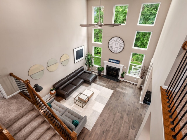 404 Colony Ridge Dr, Delaware, OH 43015 - living area featuring ceiling fan, wood finished floors, a high ceiling, a fireplace, and stairs