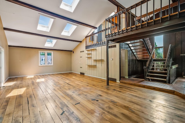 933 Creek Run Ct, Westerville, OH 43081 - unfurnished living room featuring a skylight, lofted ceiling, stairs, hardwood / wood-style flooring, and wood walls