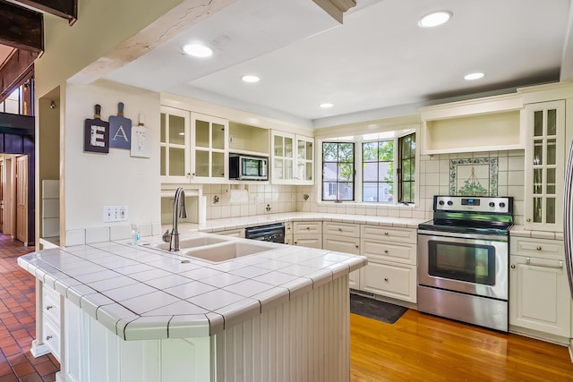 933 Creek Run Ct, Westerville, OH 43081 - kitchen with stainless steel appliances, a peninsula, tile counters, tasteful backsplash, and open shelves