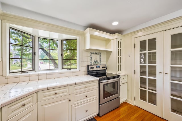 933 Creek Run Ct, Westerville, OH 43081 - kitchen featuring electric stove, tile countertops, backsplash, light wood-style floors, and recessed lighting