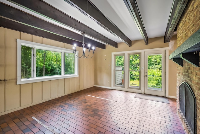 933 Creek Run Ct, Westerville, OH 43081 - unfurnished living room featuring brick patterned flooring, plenty of natural light, a chandelier, a brick fireplace, and beam ceiling