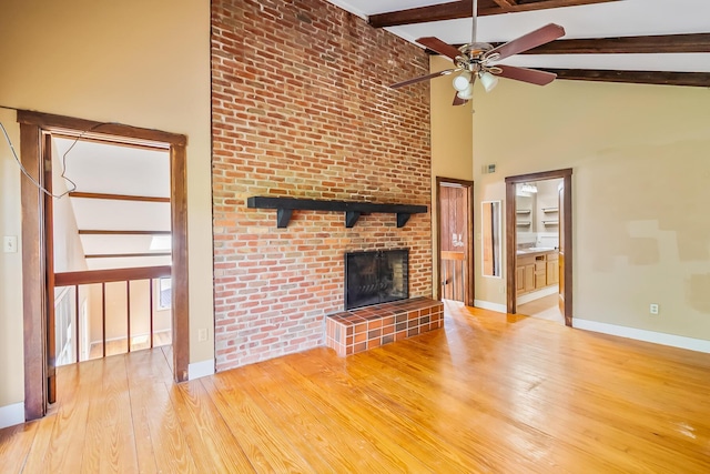 933 Creek Run Ct, Westerville, OH 43081 - unfurnished living room with ceiling fan, a fireplace, beamed ceiling, light wood-style flooring, and high vaulted ceiling
