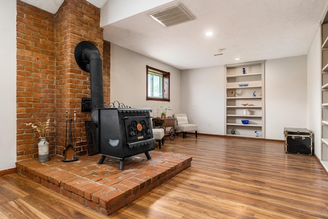 5795 Royalton Rd SW, Lancaster, OH 43130 - living area with a wood stove, wood finished floors, built in features, a textured ceiling, and recessed lighting