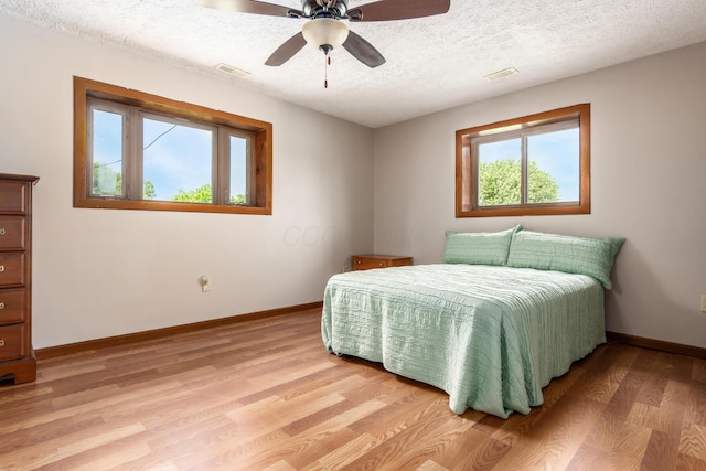 5795 Royalton Rd SW, Lancaster, OH 43130 - bedroom with light wood-style flooring, a textured ceiling, and a ceiling fan