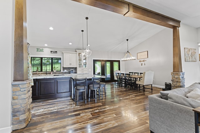 19694 State Route 60, Warsaw, OH 43844 - kitchen with white cabinets, healthy amount of natural light, dark wood finished floors, a kitchen bar, and high vaulted ceiling