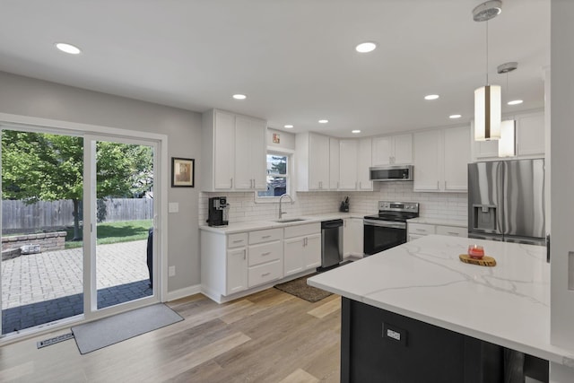 7881 Saddle, Powell, OH 43065 - kitchen featuring stainless steel appliances, white cabinets, backsplash, recessed lighting, and light wood-style flooring