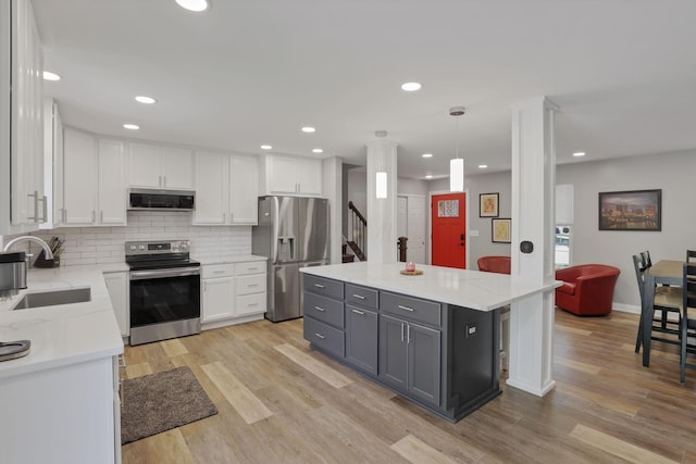 7881 Saddle, Powell, OH 43065 - kitchen featuring stainless steel appliances, white cabinetry, light wood-type flooring, tasteful backsplash, and recessed lighting