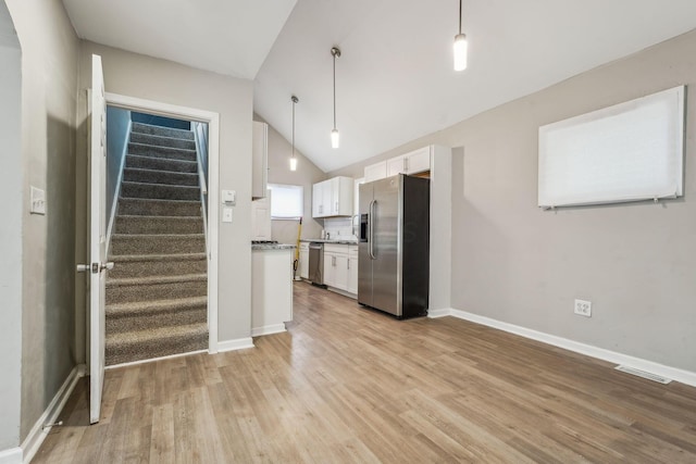 1328 Republic Ave, Columbus, OH 43211 - kitchen with appliances with stainless steel finishes, white cabinetry, light wood-style flooring, lofted ceiling, and hanging light fixtures