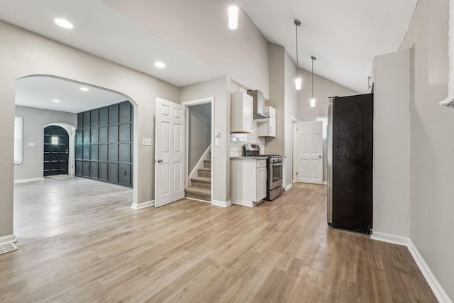 1328 Republic Ave, Columbus, OH 43211 - kitchen featuring appliances with stainless steel finishes, arched walkways, white cabinets, light wood-type flooring, and lofted ceiling