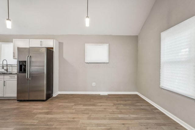 1328 Republic Ave, Columbus, OH 43211 - kitchen featuring stainless steel fridge with ice dispenser, white cabinetry, light wood finished floors, plenty of natural light, and vaulted ceiling