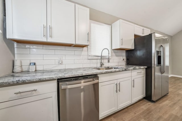 1328 Republic Ave, Columbus, OH 43211 - kitchen with appliances with stainless steel finishes, white cabinetry, backsplash, and light wood-type flooring