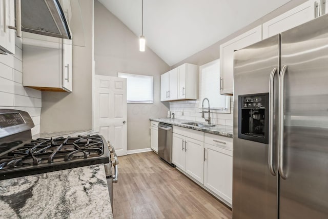 1328 Republic Ave, Columbus, OH 43211 - kitchen featuring stainless steel appliances, white cabinets, light stone counters, tasteful backsplash, and vaulted ceiling