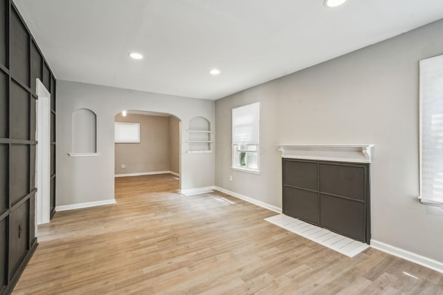1328 Republic Ave, Columbus, OH 43211 - unfurnished living room featuring arched walkways, light wood-style floors, and recessed lighting