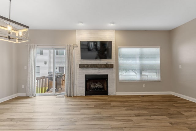 3984 Hill Park Rd, Hilliard, OH 43026 - unfurnished living room with wood finished floors, a fireplace, a chandelier, and recessed lighting
