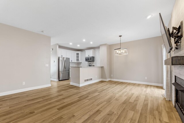 3984 Hill Park Rd, Hilliard, OH 43026 - unfurnished living room with a fireplace, light wood-style flooring, and recessed lighting