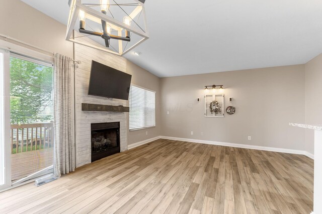 3984 Hill Park Rd, Hilliard, OH 43026 - unfurnished living room featuring wood finished floors, a fireplace, and a chandelier