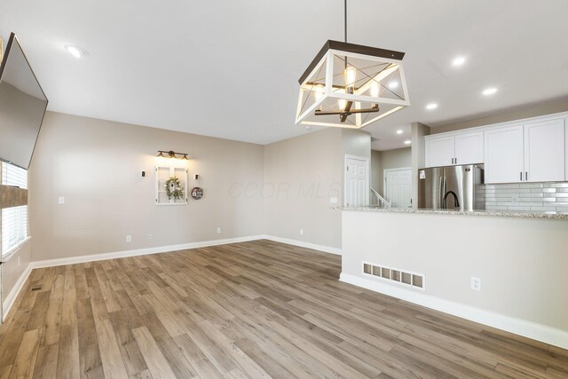 3984 Hill Park Rd, Hilliard, OH 43026 - unfurnished living room featuring a chandelier, light wood-style floors, and recessed lighting