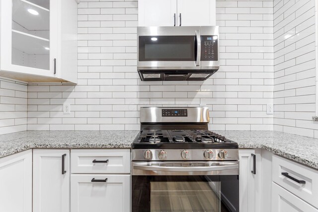 3984 Hill Park Rd, Hilliard, OH 43026 - kitchen with appliances with stainless steel finishes, tasteful backsplash, and white cabinetry