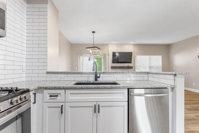 3984 Hill Park Rd, Hilliard, OH 43026 - kitchen featuring stainless steel appliances, light wood-style flooring, light stone counters, and white cabinets