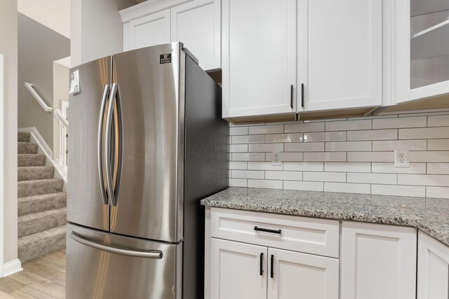 3984 Hill Park Rd, Hilliard, OH 43026 - kitchen with freestanding refrigerator, tasteful backsplash, white cabinetry, light wood-style floors, and glass insert cabinets