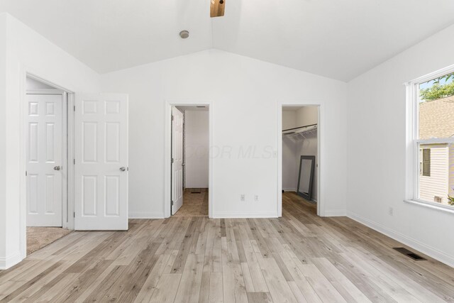 3984 Hill Park Rd, Hilliard, OH 43026 - unfurnished bedroom with a walk in closet, lofted ceiling, light wood-type flooring, a closet, and ceiling fan