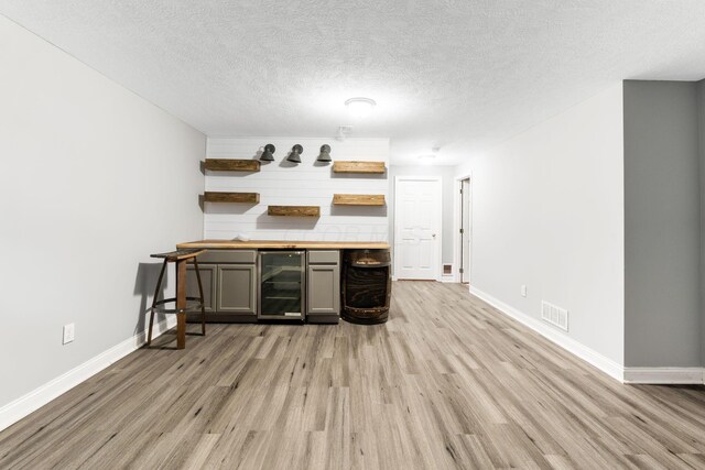 3984 Hill Park Rd, Hilliard, OH 43026 - indoor dry bar with beverage cooler, light wood-type flooring, and a textured ceiling