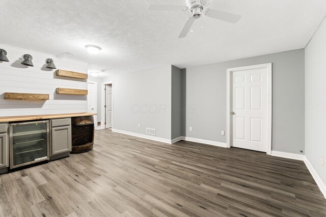 3984 Hill Park Rd, Hilliard, OH 43026 - indoor dry bar with wine cooler, wood finished floors, a ceiling fan, and a textured ceiling