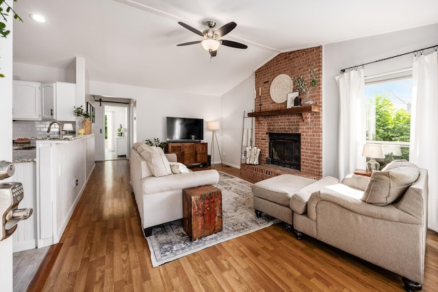 3776 Secretariat Ct, Columbus, OH 43221 - living area featuring light wood finished floors, lofted ceiling, ceiling fan, a brick fireplace, and recessed lighting