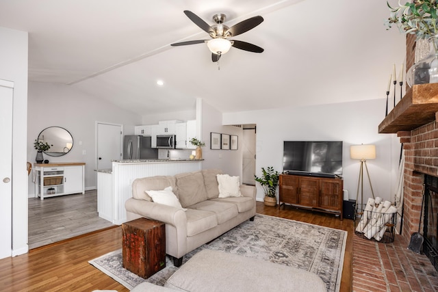 3776 Secretariat Ct, Columbus, OH 43221 - living room with a brick fireplace, ceiling fan, lofted ceiling, and wood finished floors
