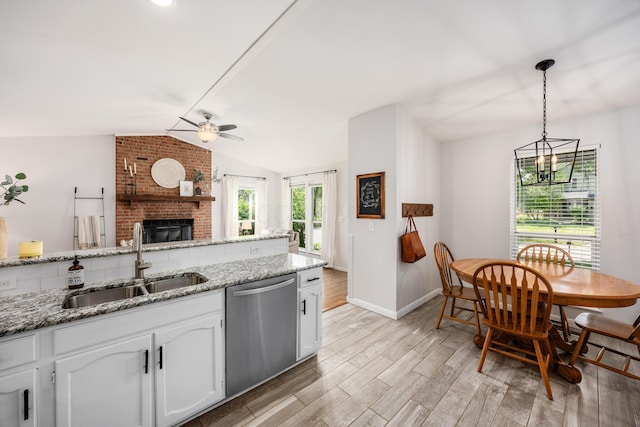 3776 Secretariat Ct, Columbus, OH 43221 - kitchen featuring stainless steel dishwasher, vaulted ceiling, a ceiling fan, light wood-style flooring, and a fireplace