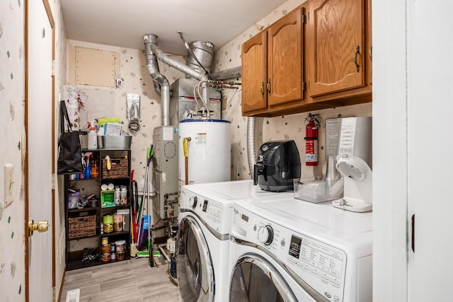 3776 Secretariat Ct, Columbus, OH 43221 - laundry room with water heater, cabinet space, washing machine and dryer, and light wood-type flooring