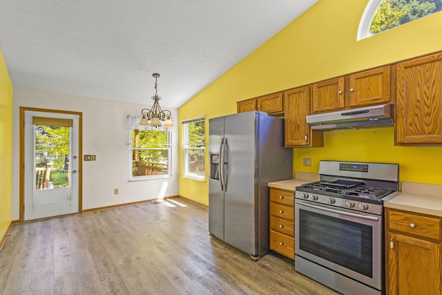 8544 Cadence Dr, Galloway, OH 43119 - kitchen featuring stainless steel appliances, under cabinet range hood, vaulted ceiling, a chandelier, and brown cabinets