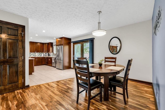 13283 Clover Valley Rd, Croton, OH 43013 - dining area featuring light wood-type flooring, a textured ceiling, and recessed lighting