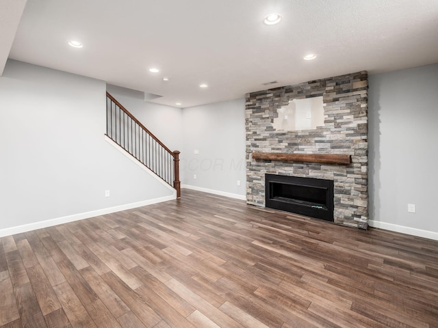 1719 Impatiens Way, Lewis Center, OH 43035 - unfurnished living room with wood finished floors, stairs, recessed lighting, and a stone fireplace
