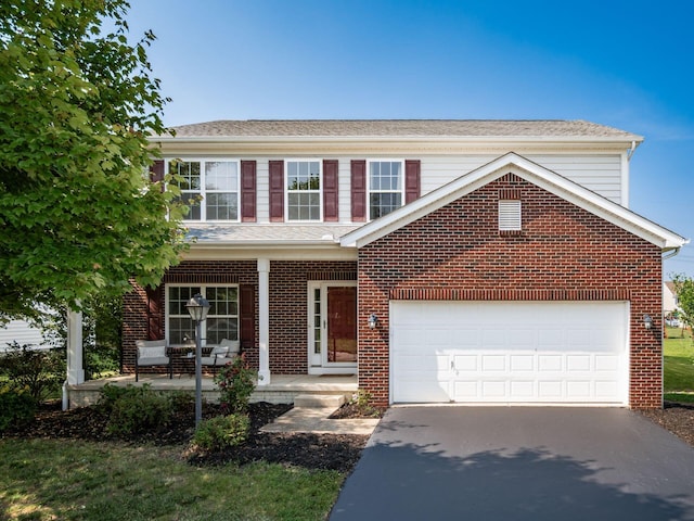 1719 Impatiens Way, Lewis Center, OH 43035 - traditional home featuring a porch, driveway, brick siding, and a garage