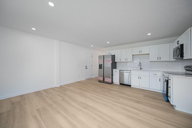 1874 Fleming Rd, Columbus, OH 43232 - kitchen with appliances with stainless steel finishes, light wood-style floors, light countertops, backsplash, and recessed lighting
