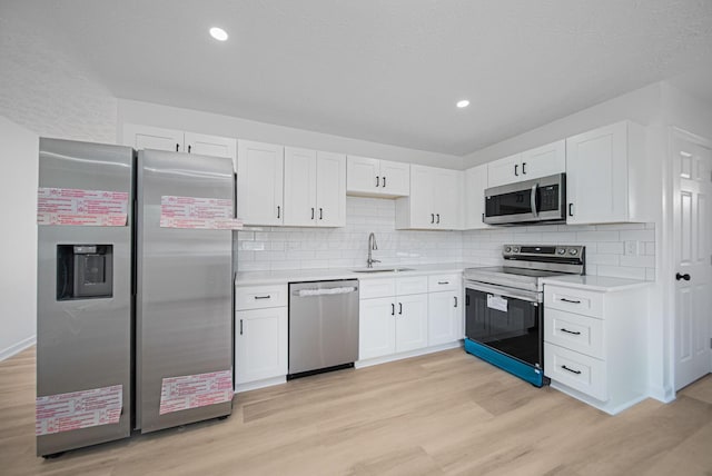 1874 Fleming Rd, Columbus, OH 43232 - kitchen featuring appliances with stainless steel finishes, light countertops, light wood-style floors, white cabinets, and recessed lighting