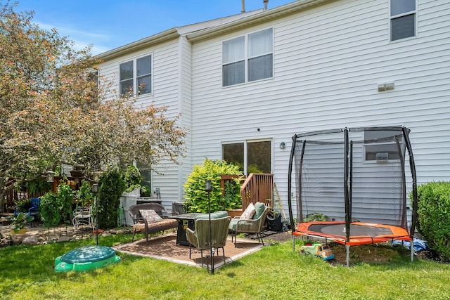 3956 Darby Park Rd, Hilliard, OH 43026 - back of property featuring a trampoline, a patio area, and a lawn