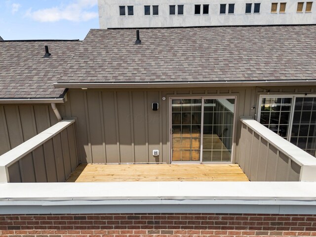 91 W Town St, Columbus, OH 43215 - view of exterior entry featuring board and batten siding, a shingled roof, and a deck