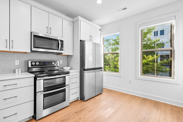 91 W Town St, Columbus, OH 43215 - kitchen with stainless steel appliances, light countertops, backsplash, light wood-style floors, and recessed lighting