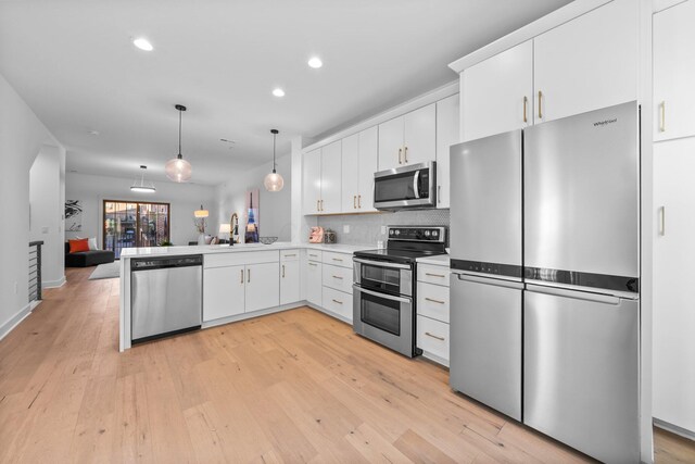 91 W Town St, Columbus, OH 43215 - kitchen featuring appliances with stainless steel finishes, light wood-type flooring, hanging light fixtures, recessed lighting, and white cabinets