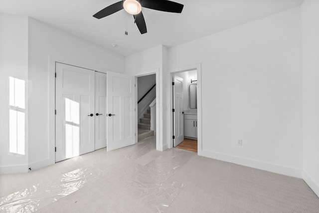 91 W Town St, Columbus, OH 43215 - unfurnished bedroom with connected bathroom, a closet, carpet floors, and a ceiling fan